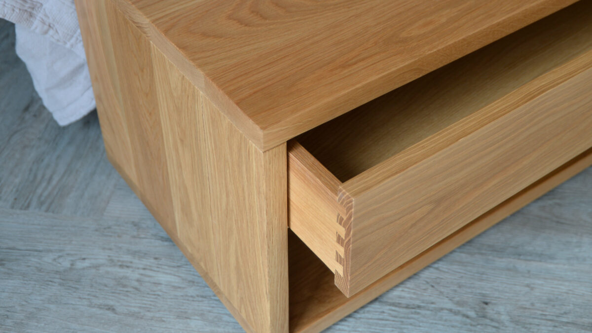 low oak media unit or bench with storage drawer shown in close up with drawer open