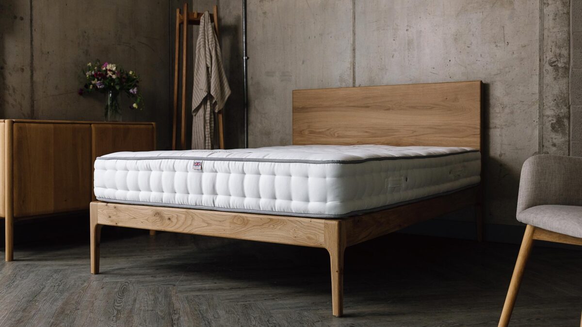 A low angled shot of the English oak Chiswick, which has a bare mattress on top of it.