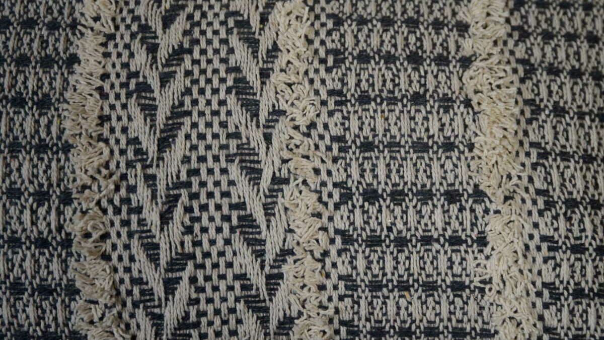 a close up look at our textured Boho cushions with a woven and tufted geometric pattern in black and ivory