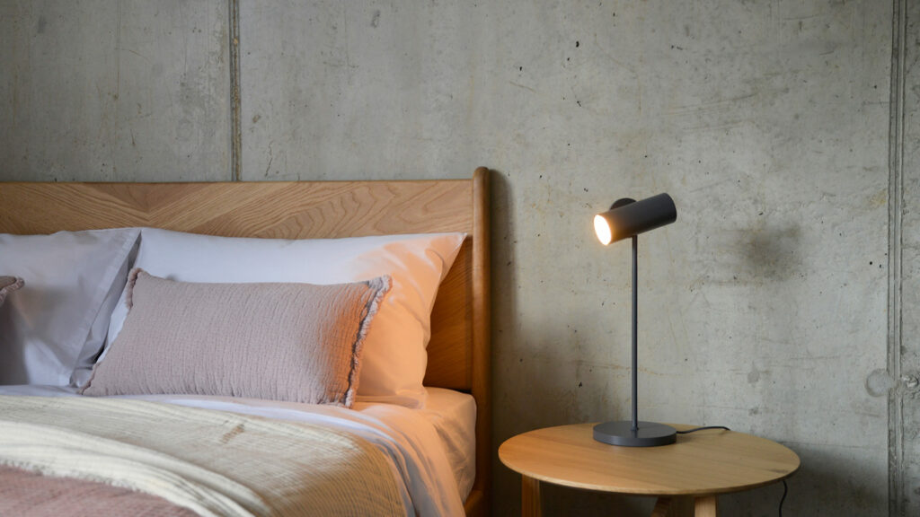 adjustable spotlight in slate grey used as a bedside lamp