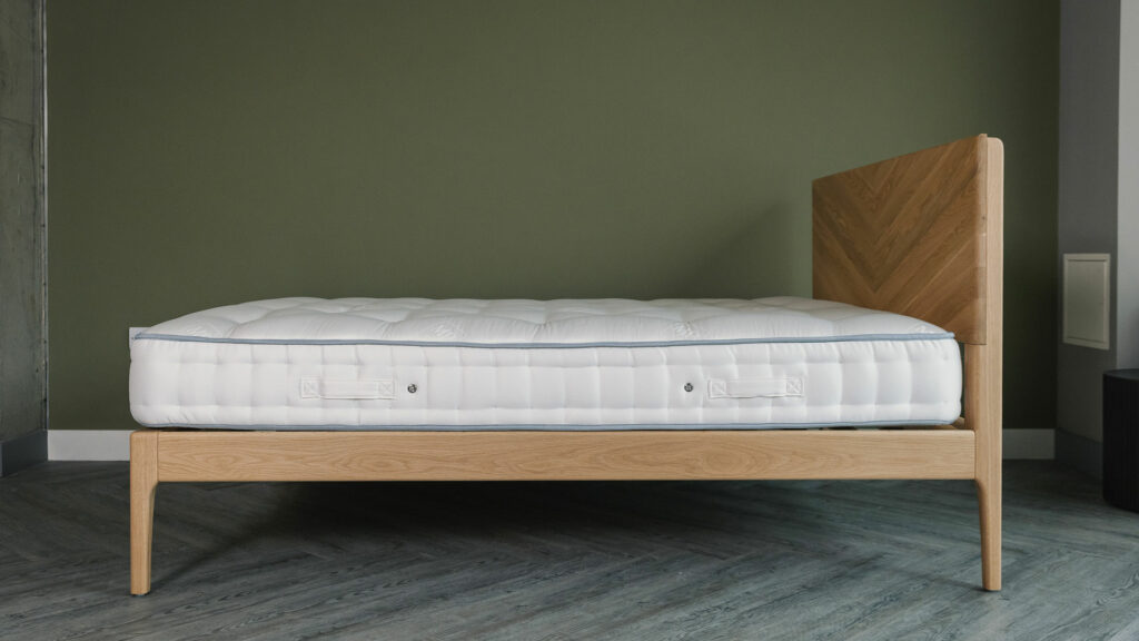 a side view of our oak Highbury bed in kingsize shown without bedding