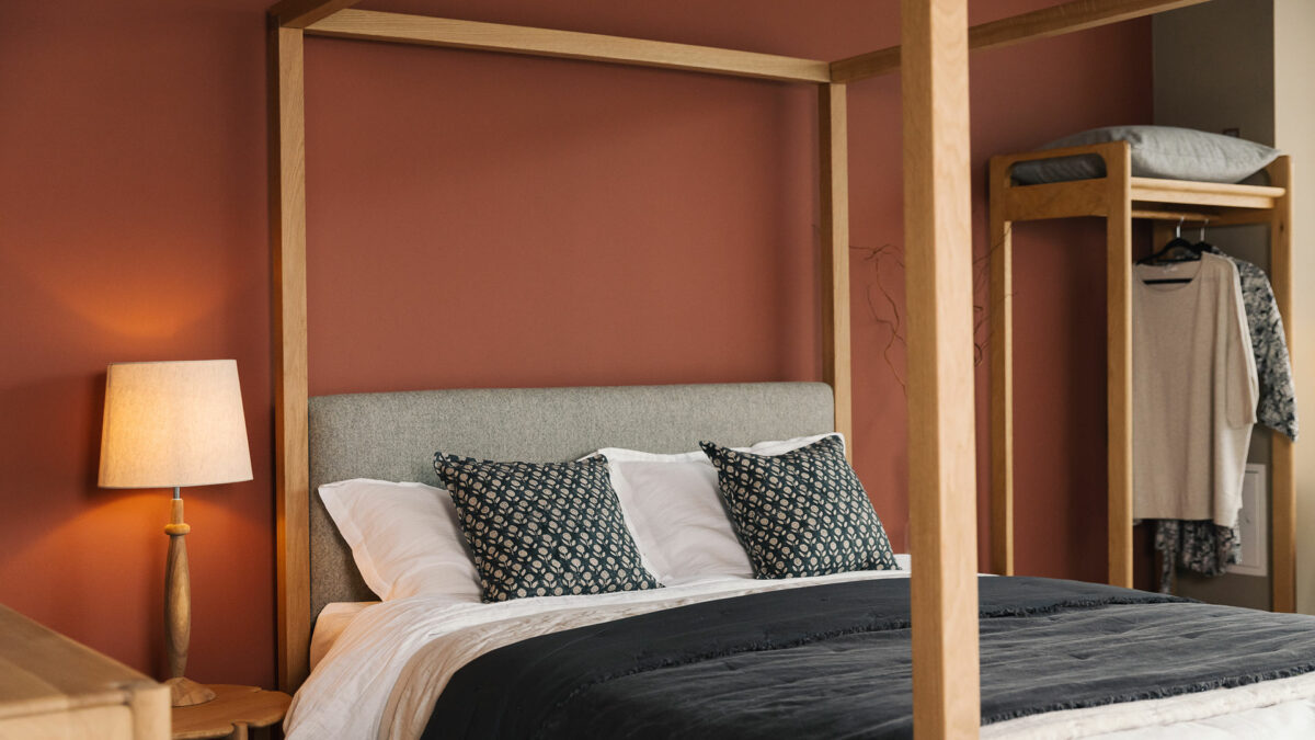 Highland bed with dark grey cushions and quilt