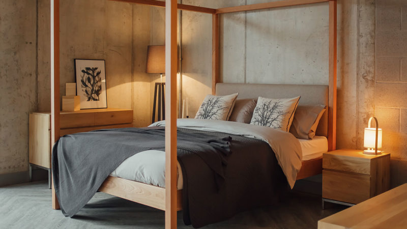 Cosy concrete bedroom featuring our hand-made Highland solid wood upholstered 4 Poster bed in cherry