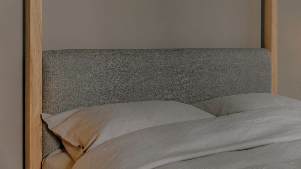 A closer view of the solid Oak Highland 4 poster bed with its upholstered headboard