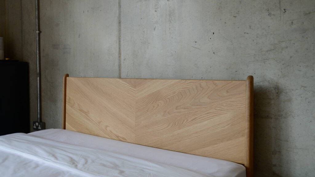 Our mid-century style Hoxton solid wood bed has a chevron pattern to the headboard here in close-up