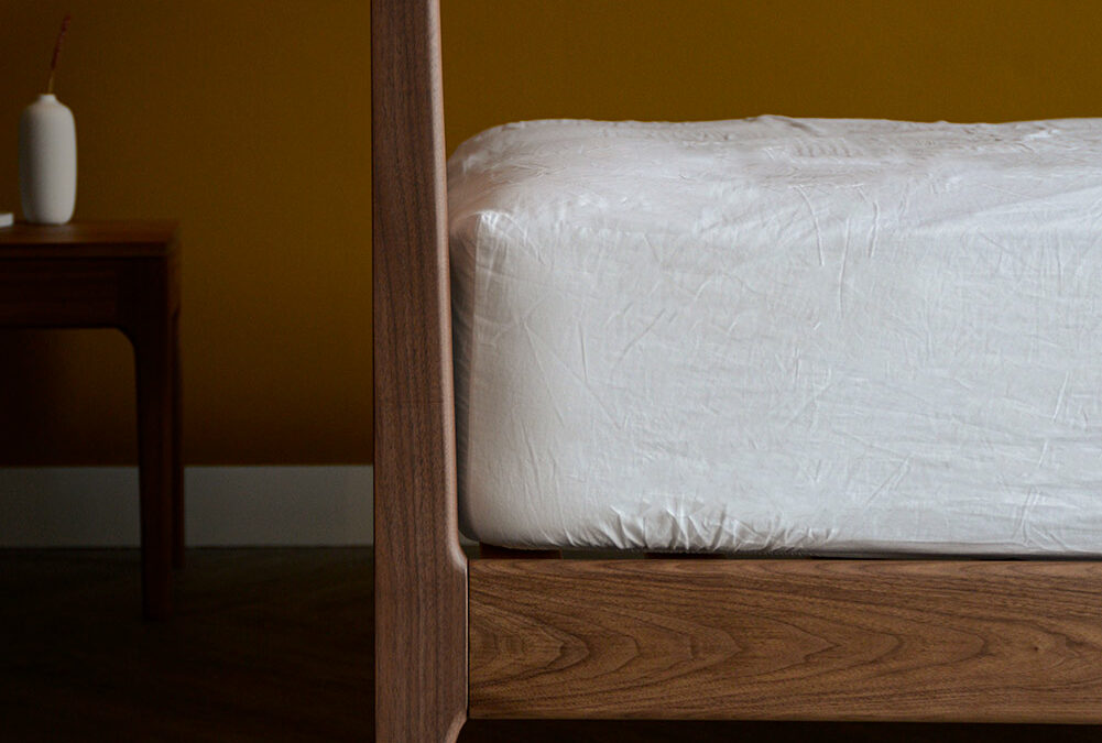 the Hoxton handcrafted solid wood bed here made in Walnut is shown in a close up of the headboard leg join