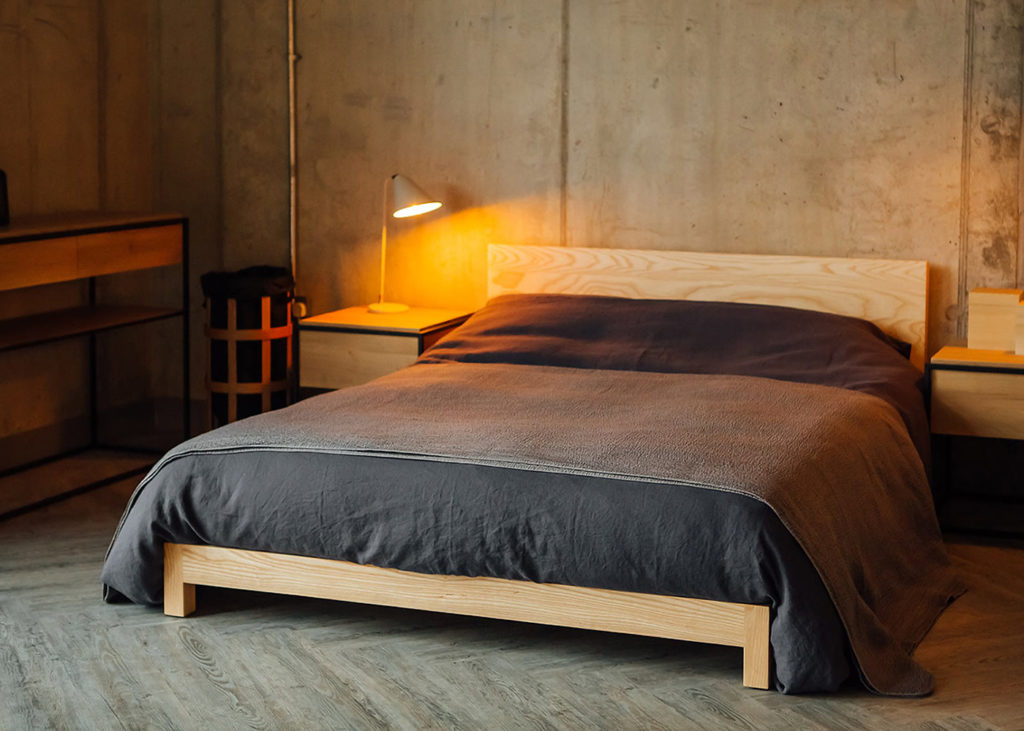 Industrial look bedroom concrete walls and a pale Ash low wooden Sonora bed