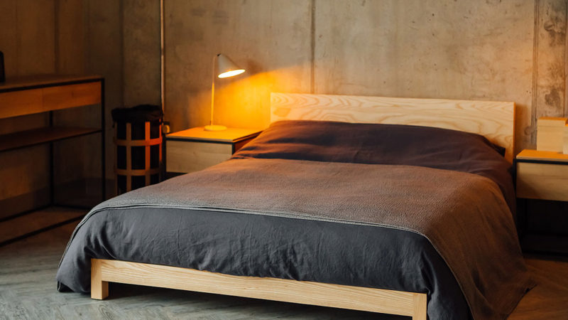 Industrial look bedroom concrete walls and a pale Ash low wooden Sonora bed