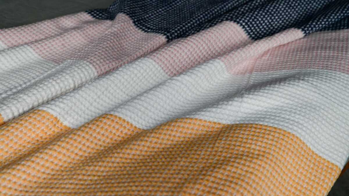 waffle weave knitted throw in pink, white, orange and navy