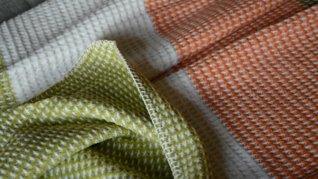 waffle weave knitted throw in green, white and orange