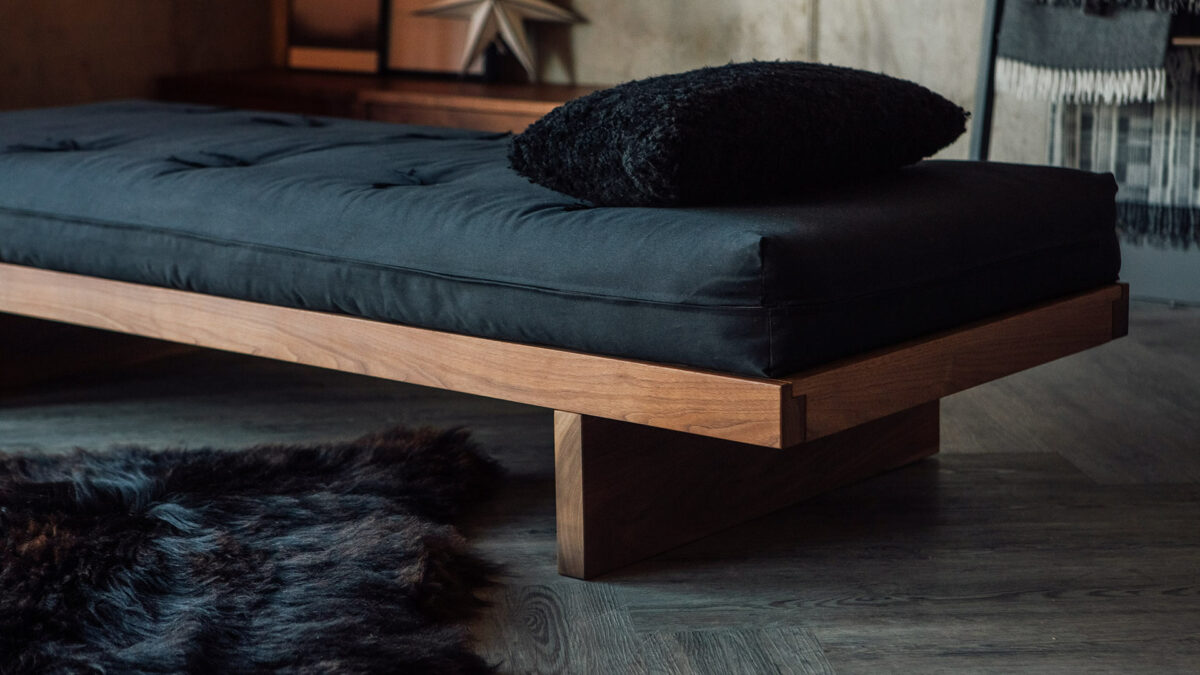 A close-up of the solid walnut Kyoto Daybed with futon mattress, all hand made in Britain