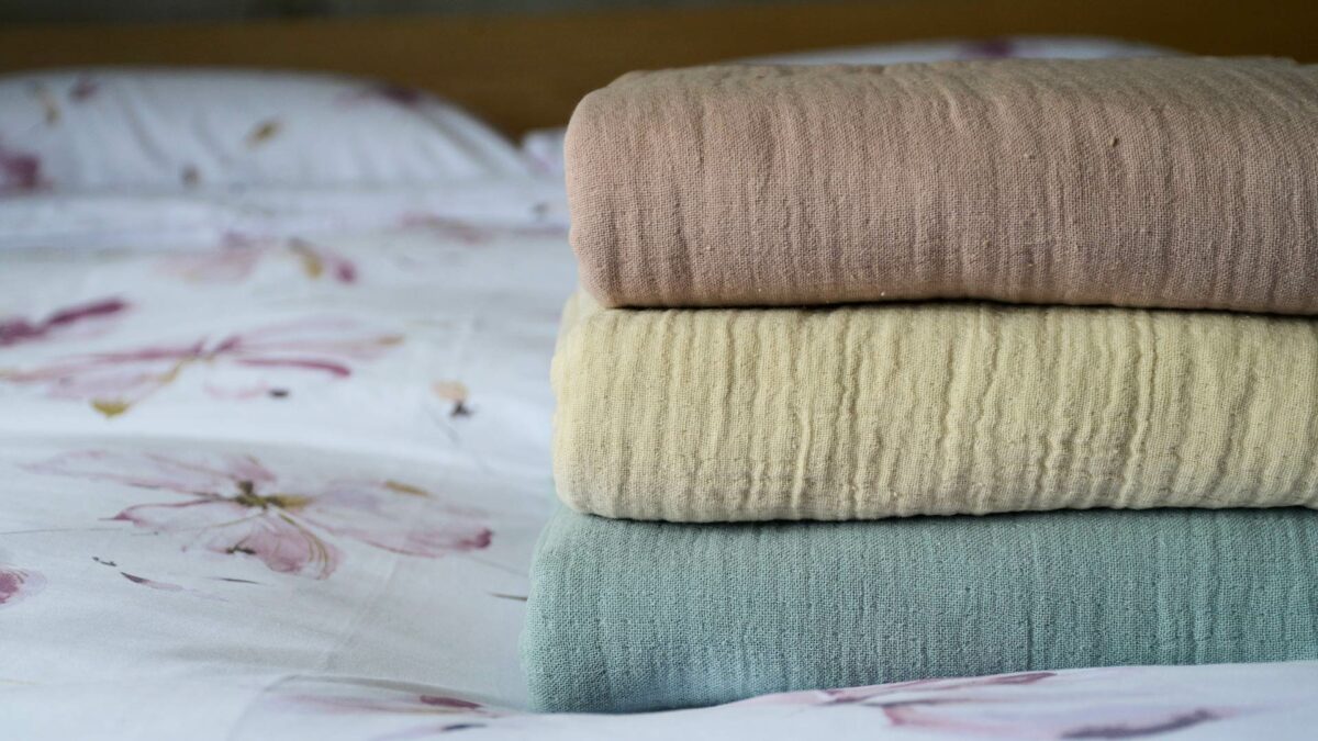 light weight bedspreads in 3 colours shown as a stack