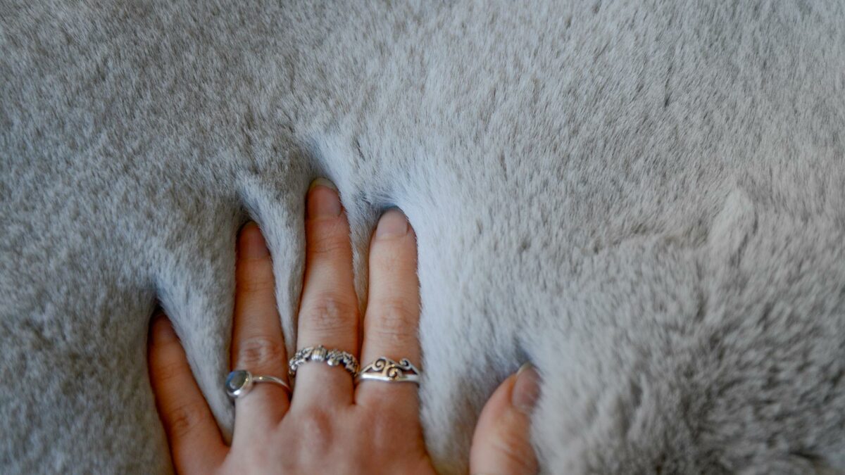 Malini Deep Pile Grey Faux Fur Throw with hand to show pile