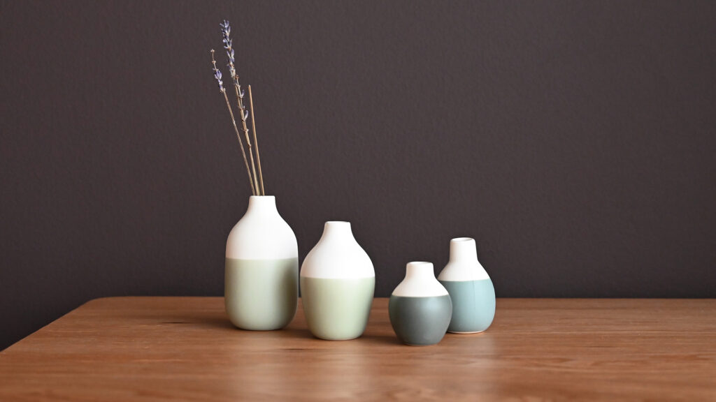 4 mini vases, different heights and different shades of blue.
