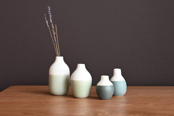 4 mini vases, different heights and different shades of blue.