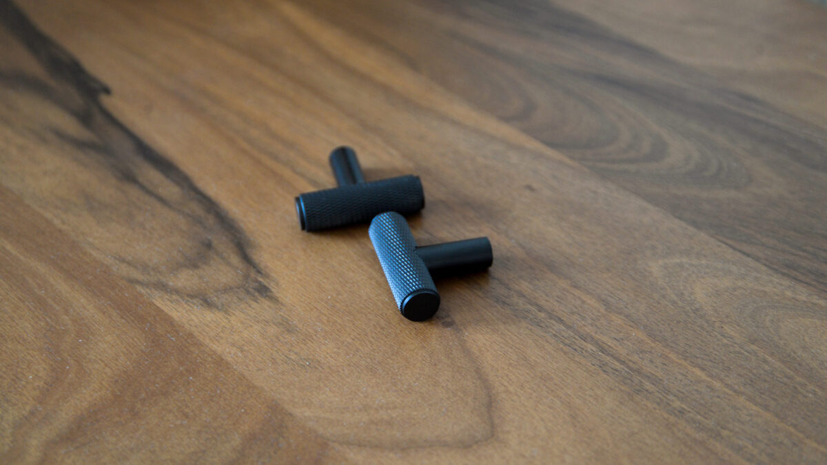 two black T bar hooks on a table.