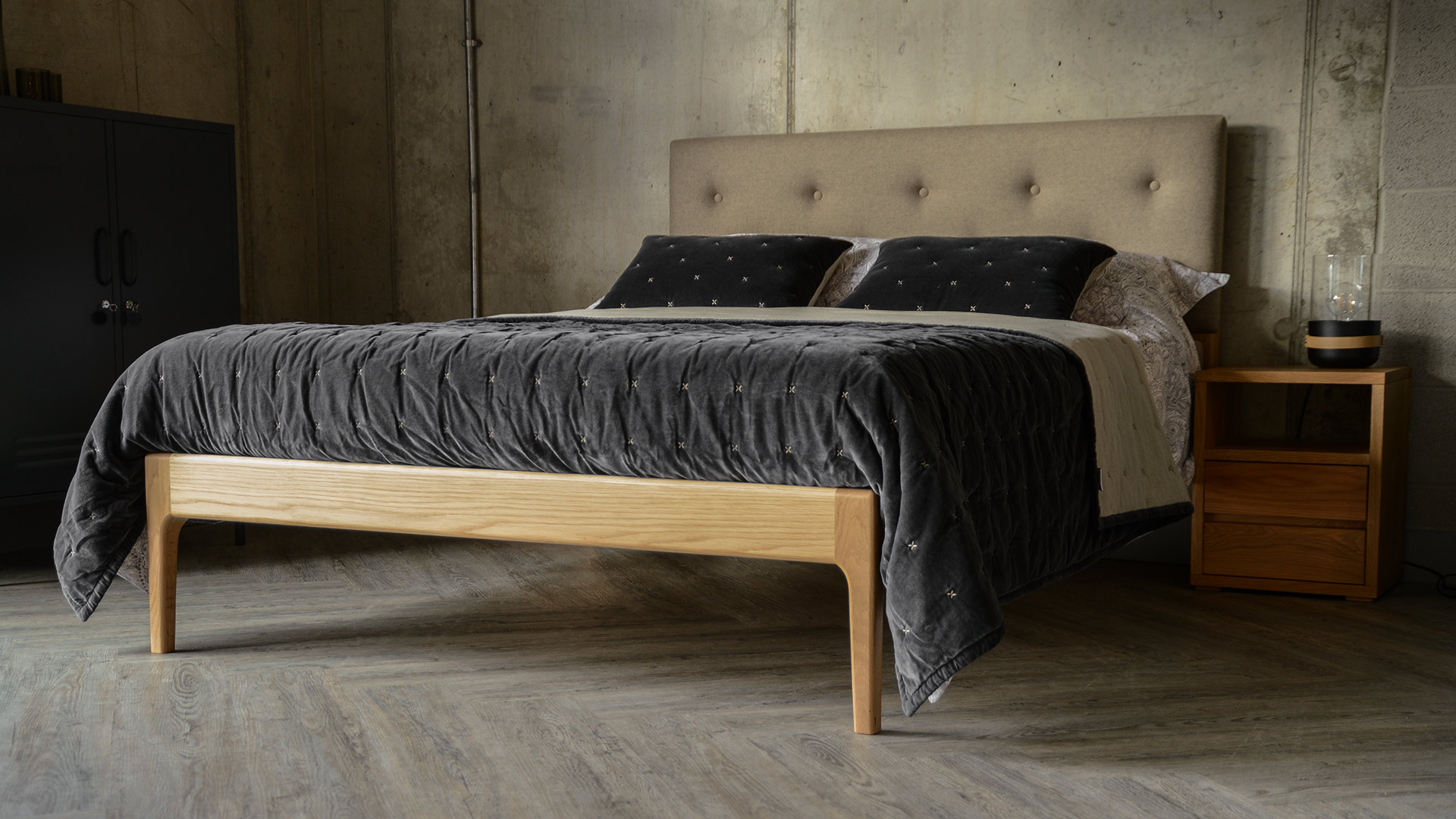 Upholstered solid oak hand crafted bed with soft grey velvet quilt