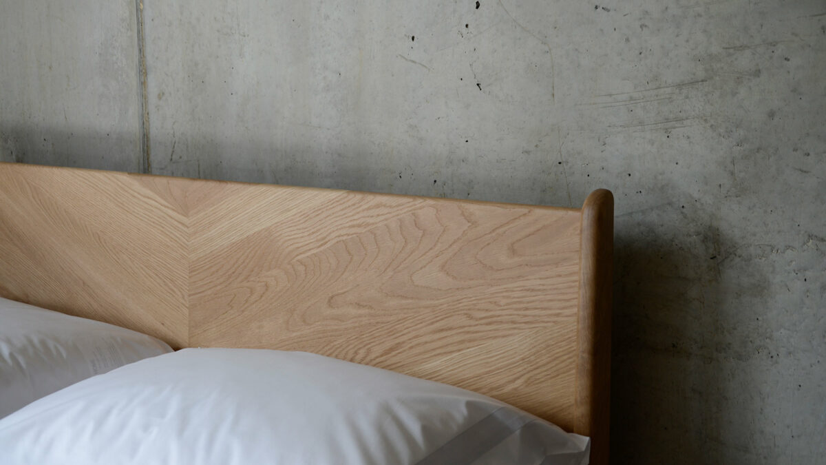 A closer view of the chevron design solid wood headboard of the Oak Hoxton bed