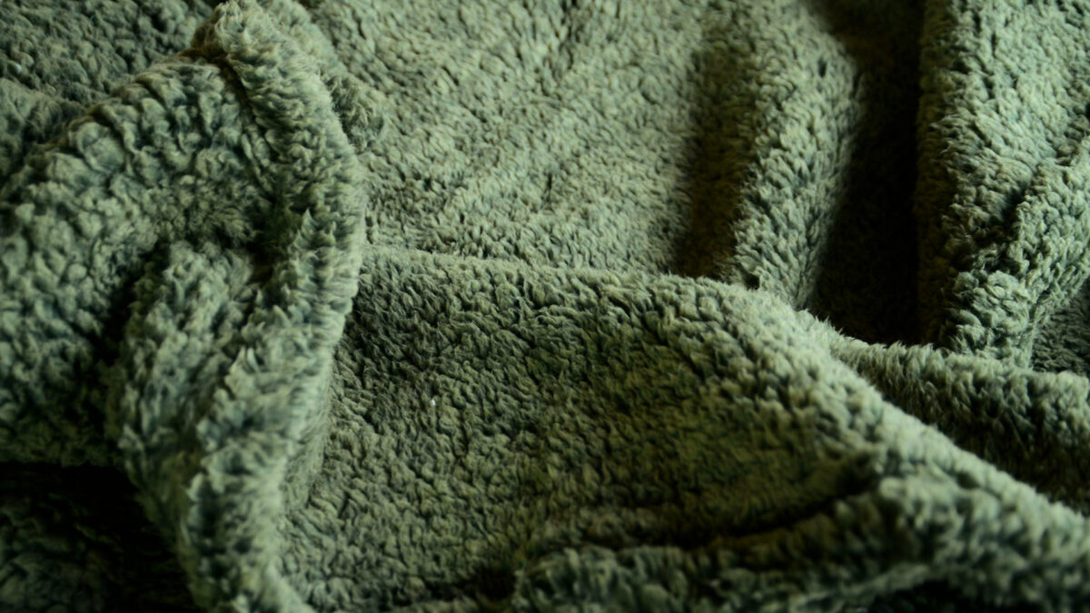 Olive green marl soft and cozy fleecey throw shown close up