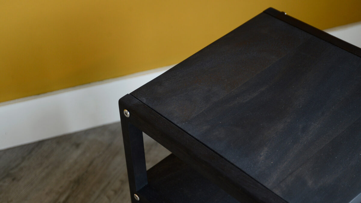 open shelf wooden bedside table with a dark earth stain a view of the top