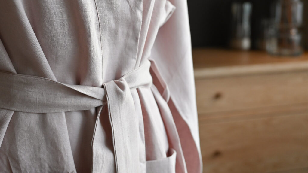 Close up of tie detail on pale pink linen robe.