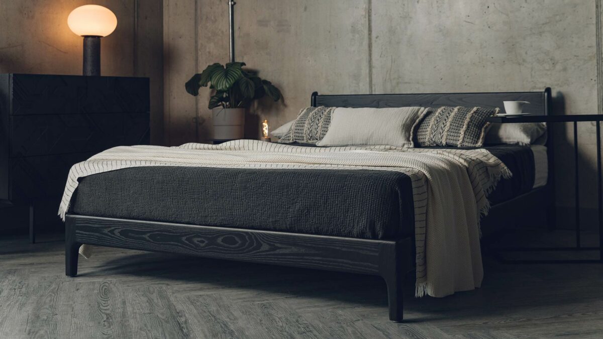 The Pimlico low bed here is made from black stained solid Ash wood and is shown with bedding in black and sand tones