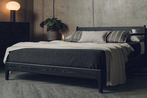 The Pimlico low bed here is made from black stained solid Ash wood and is shown with bedding in black and sand tones