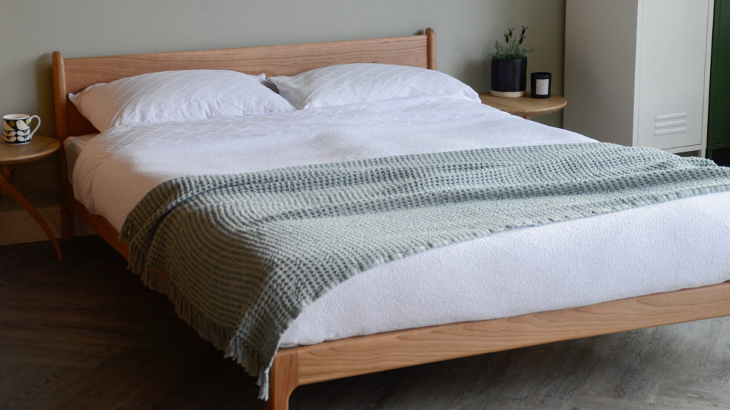 Fresh spring bedding look on the low, solid wood Pimlico bed made in cherry