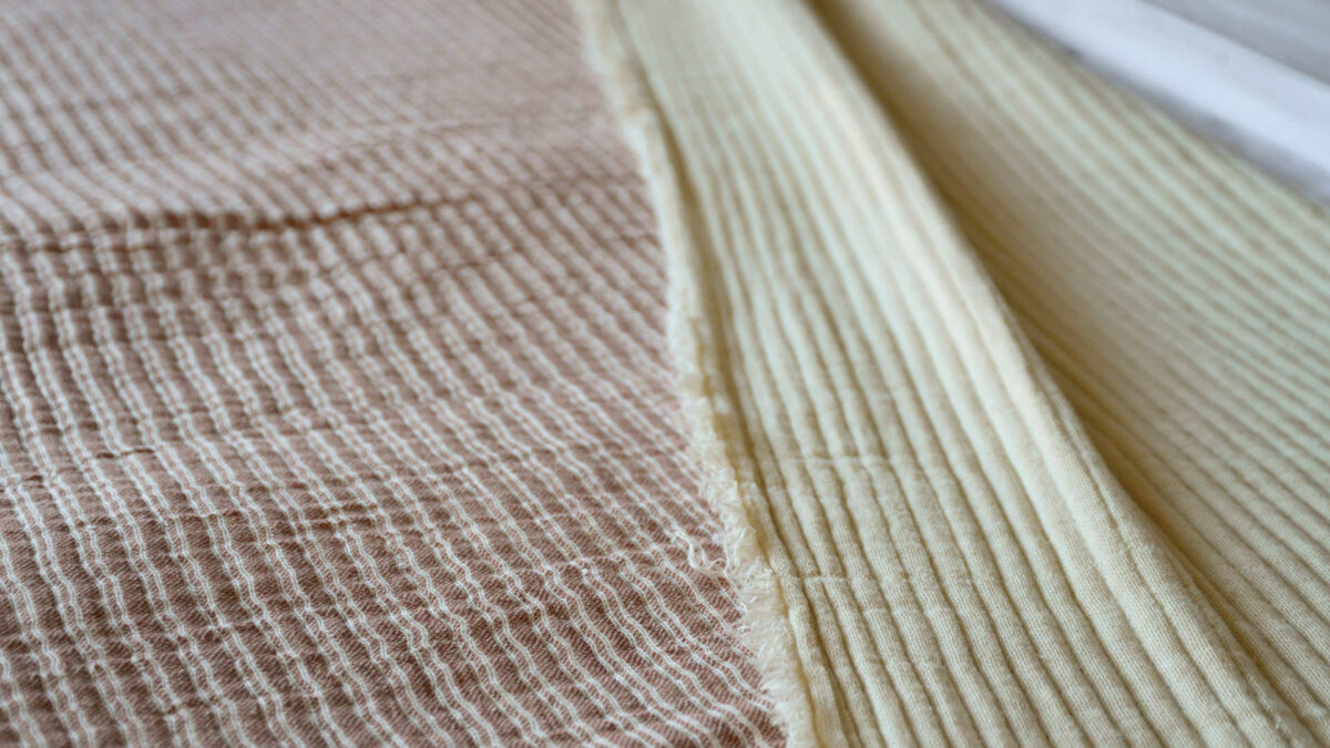 reversible textured cotton bedspread pink striped one side plain cream reverse a close-up view