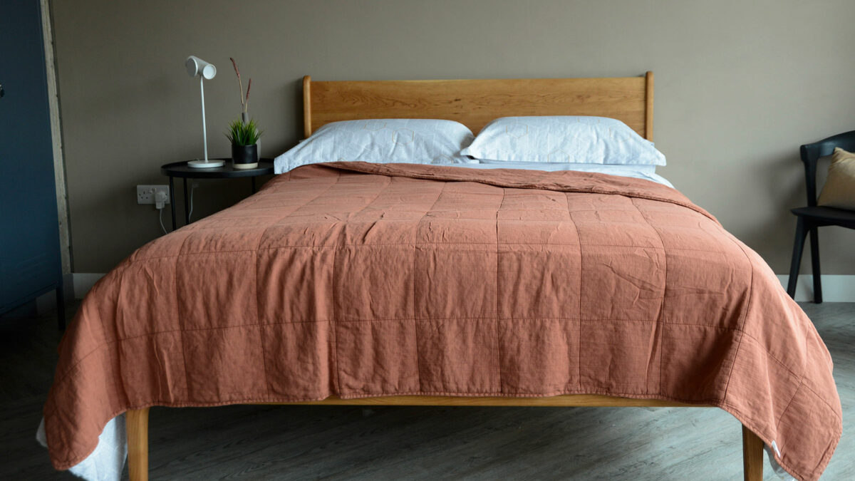 soft quilted cotton bedspread in terracotta shown on a Kingsize Camden bed