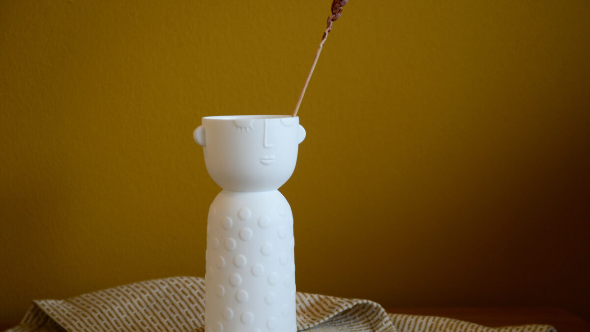 white porcelain vase or candle holder with face