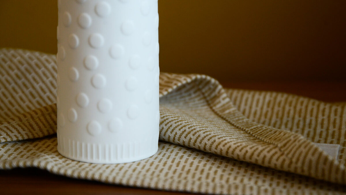 white porcelain vase or candle holder with face a close up of the base