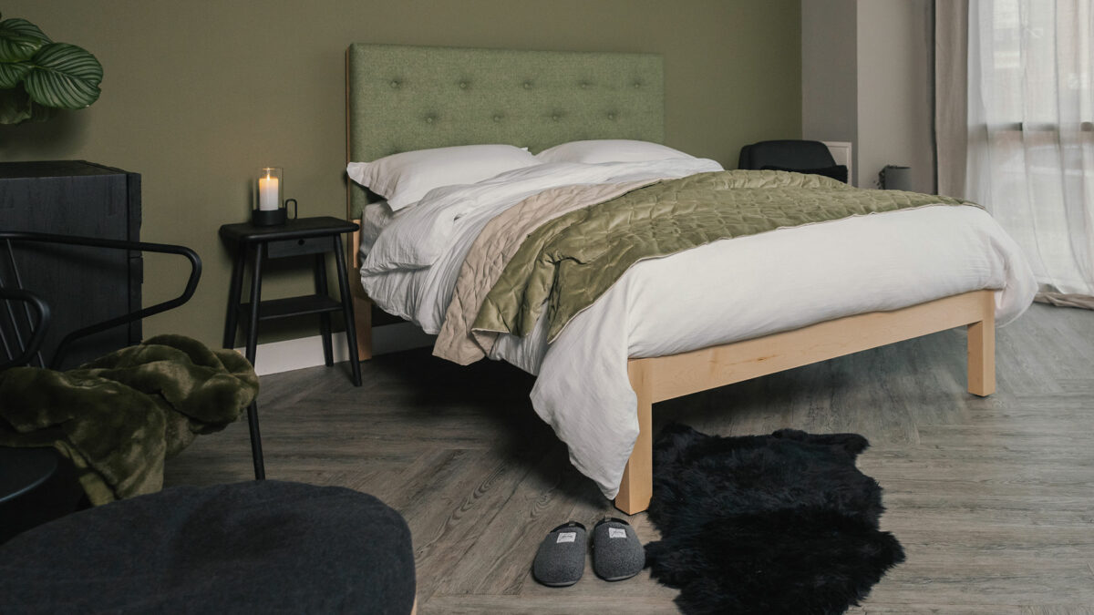 Skye a wooden bed with tall headboard panel upholstered in a green Parquet wool fabric