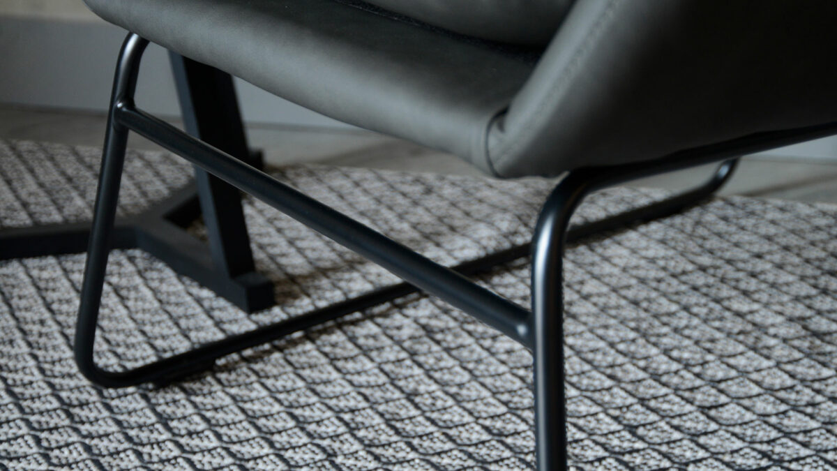 charcoal grey armchair with a black painted sled base