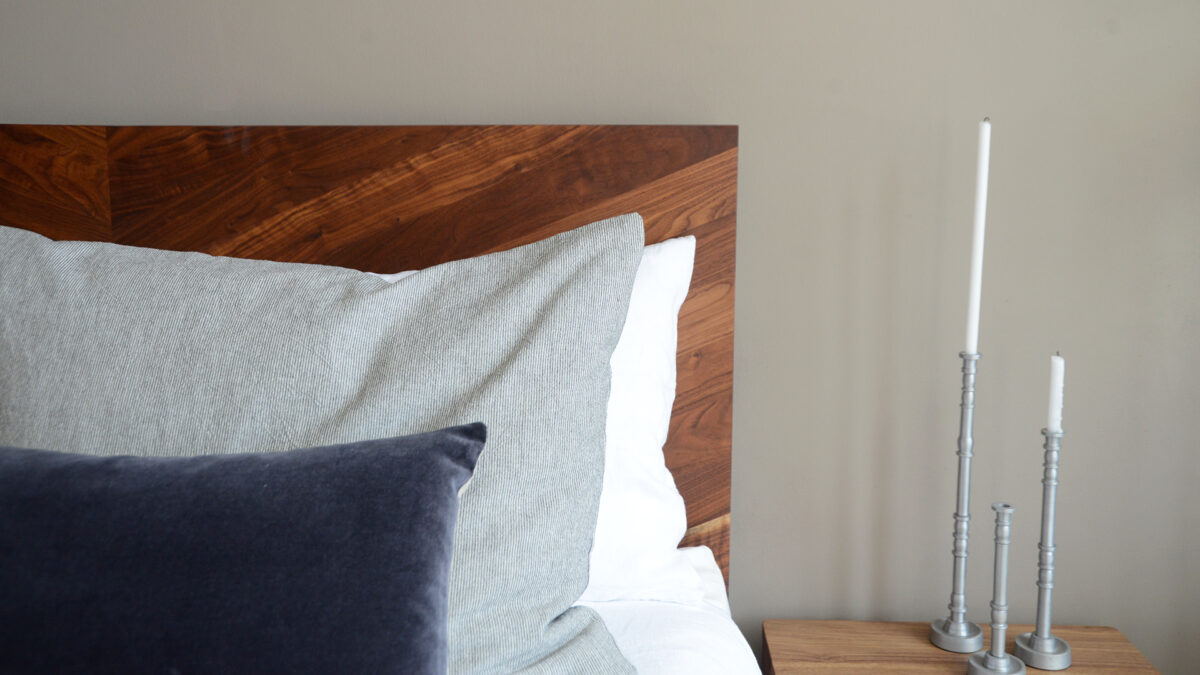 narrow striped large cotton cushions shown on a bed