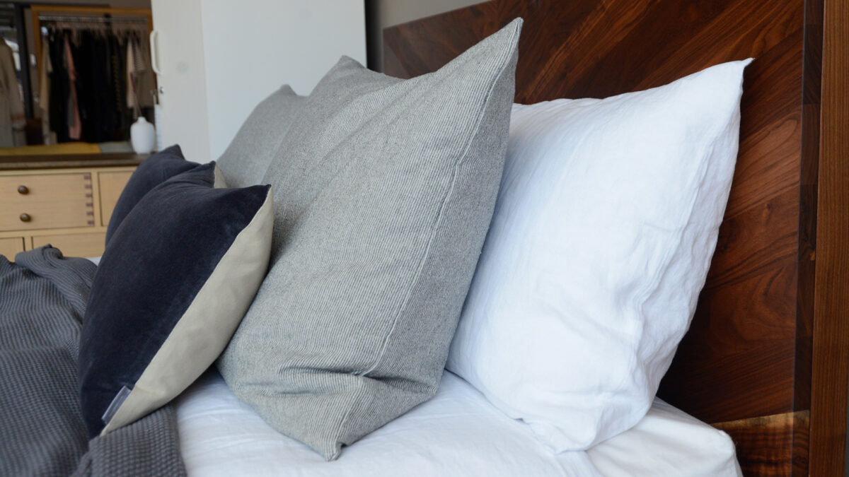 narrow striped large cotton cushions shown on a bed