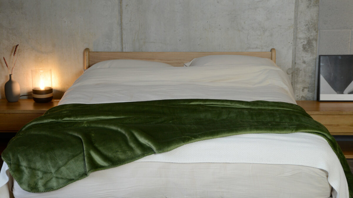 soft and cosy microfibre fleece throw in Olive green shown on a kingsize bed