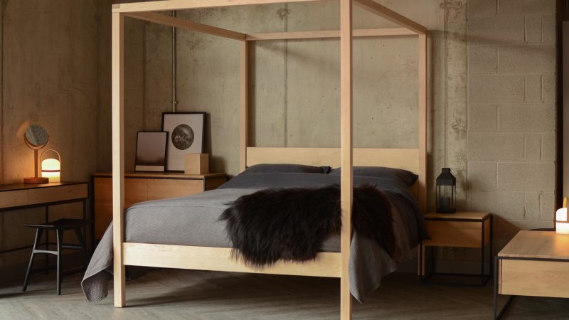 A contemporary handcrafted 4 poster bed this Orchid bed in Maple with dark bedding has a Scandinavian style