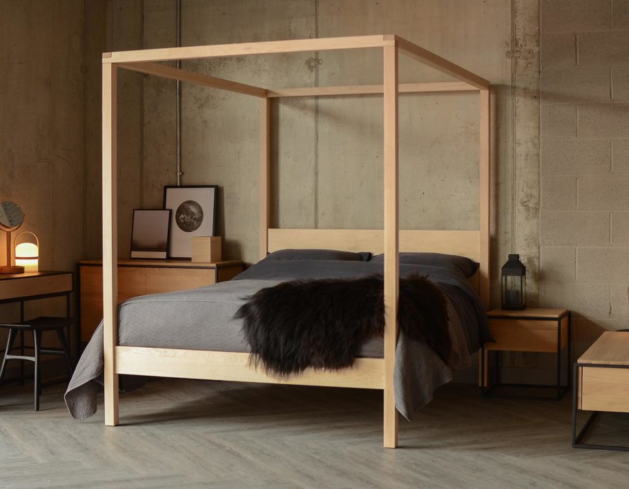 A contemporary handcrafted 4 poster bed this Orchid bed in Maple with dark bedding has a Scandinavian style