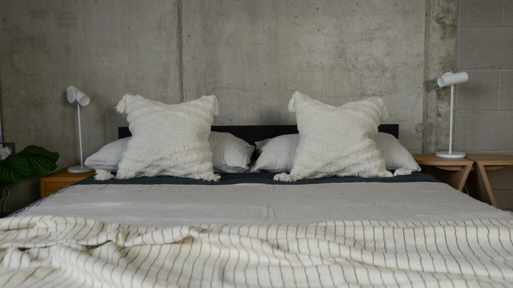 Morocco inspired tufted and tasselled ivory cushions shown on a kingsize bed