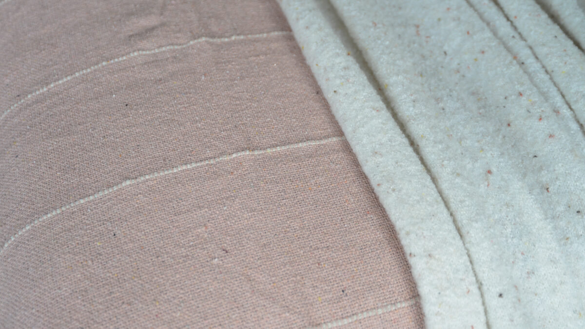 striped textured cotton bedspread in blush pink and ivory shown up close