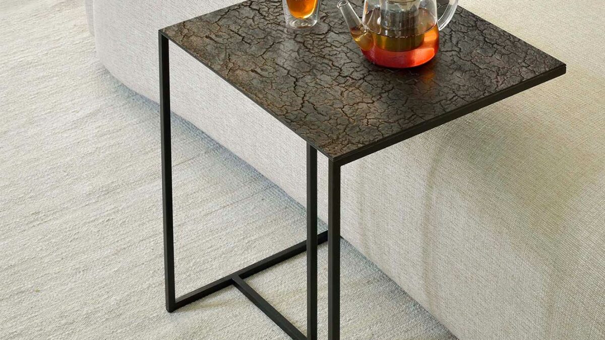 overhanging side table with a black metal frame and cracked larva effect top