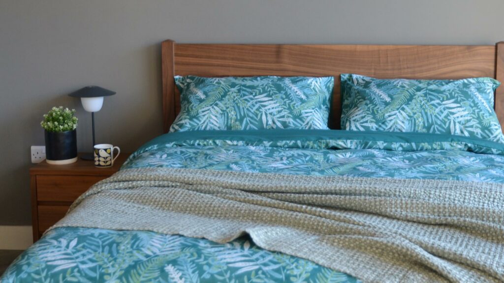 Teal-coloured tropical leaves print duvet cover set on our walnut wood Cochin bed fame