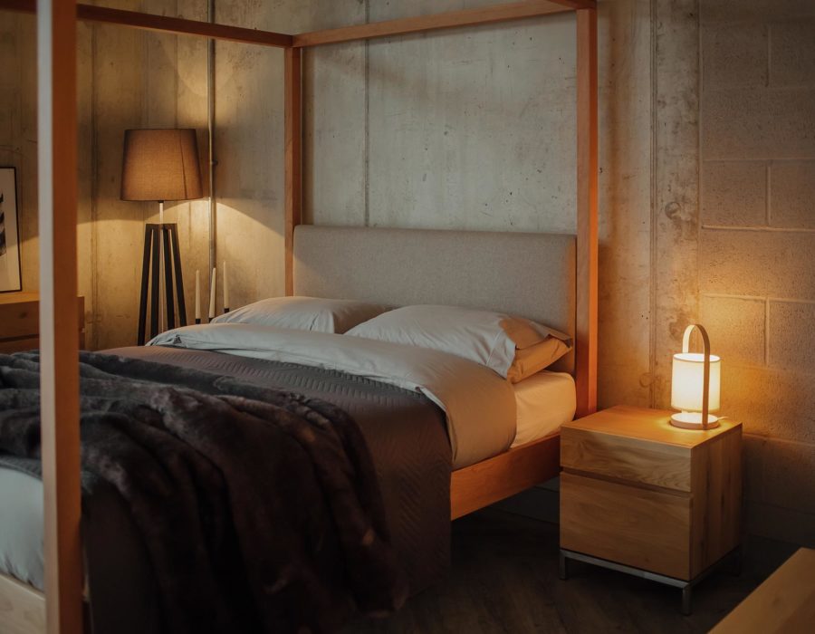 Highland 4 poster wooden bed with upholstered headboard given a cosy look with a luxury faux fur bedspread