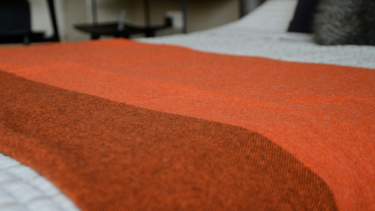 100% pure wool colour block throw in orange with brown undertones