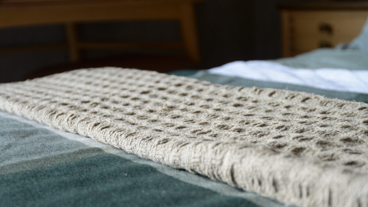 textured weave fringe edged throw in a stone colour