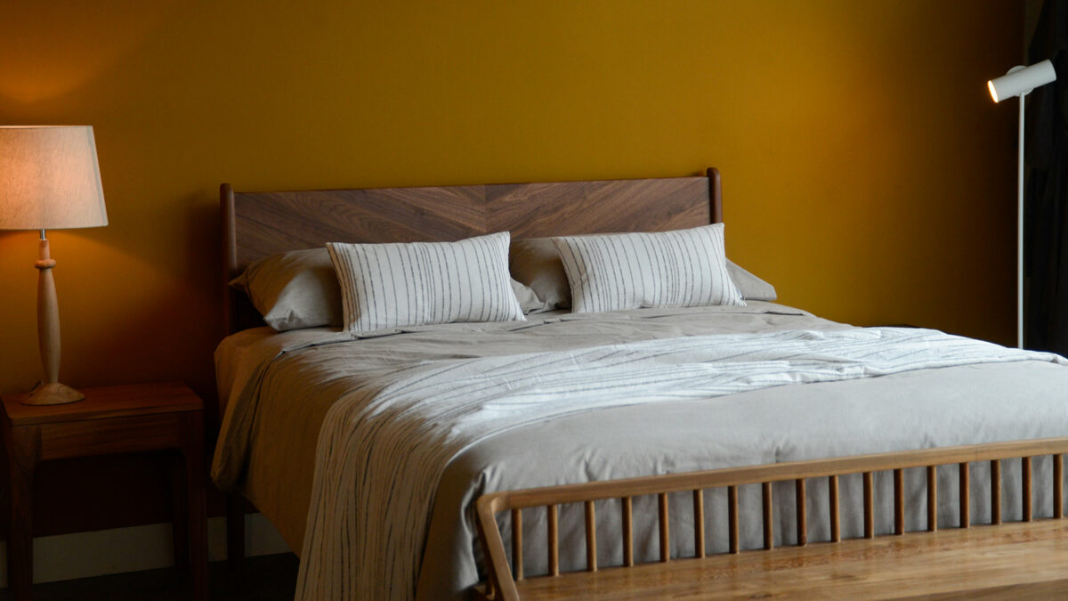 Jacquard weave white cotton cushions and matching throw with stripe in charcoal shown on a kingsize bed