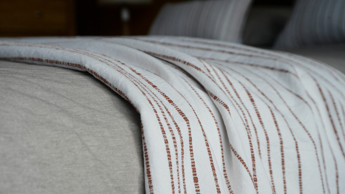 Jacquard weave white cotton throw with stripe in terracotta