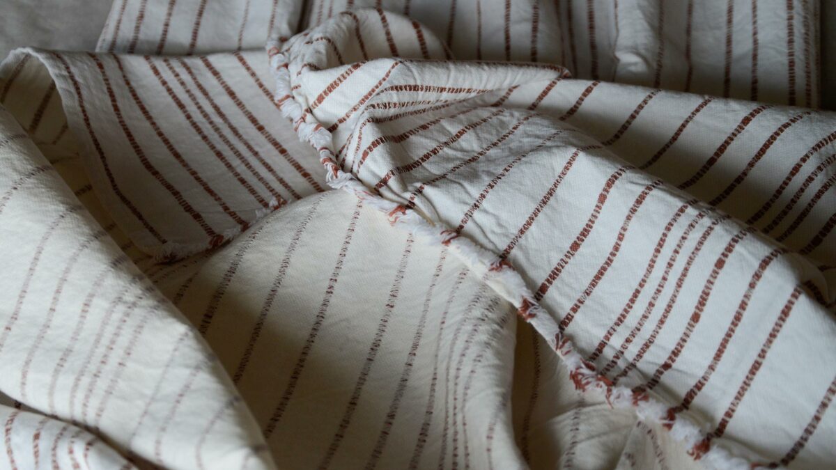 Jacquard weave white cotton throw with stripes in terracotta