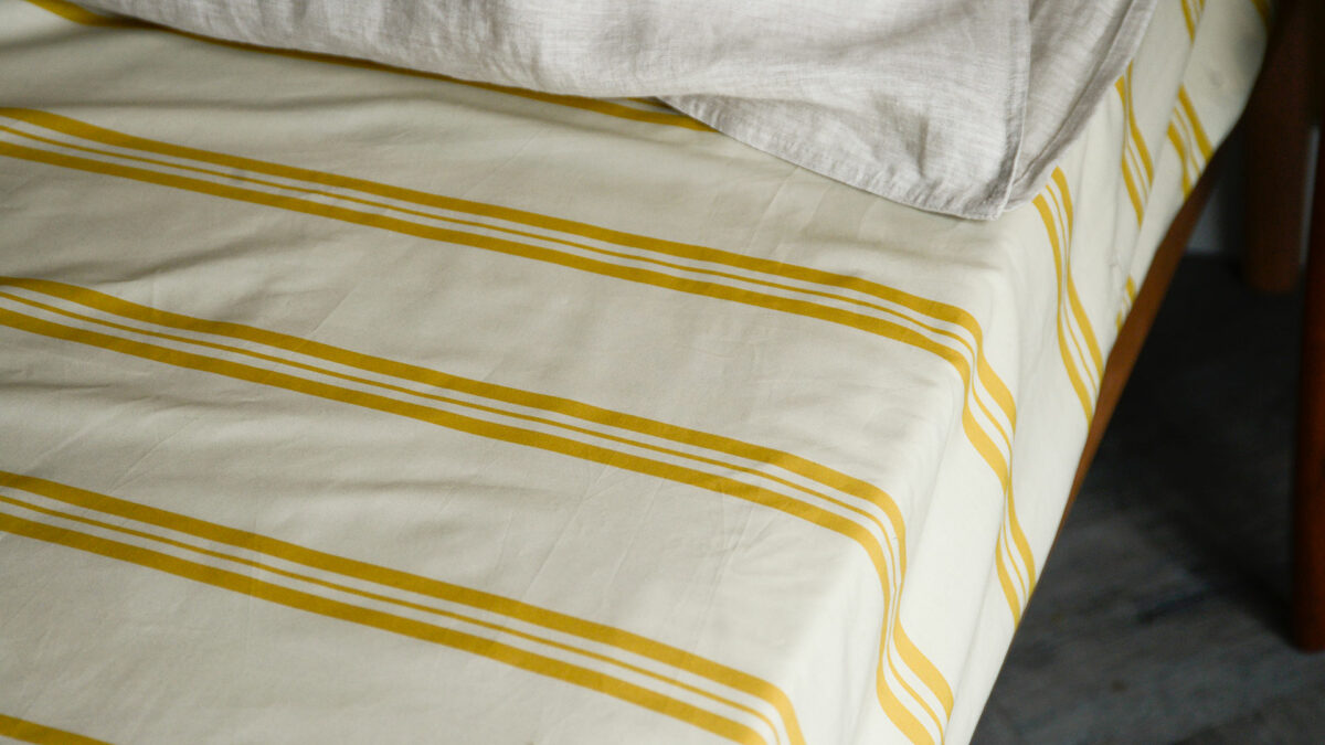 fitted sheet and pillowcase set with mustard yellow stripes a close up view